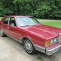 1983 Red Lincoln Continental 4-door sedan.
